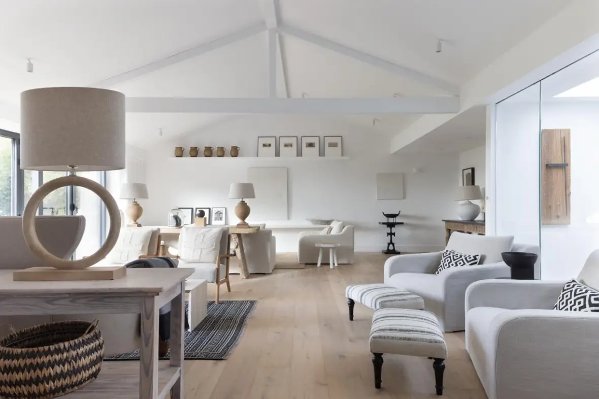 An airy, neutral-toned living space with light wood floors and white walls.