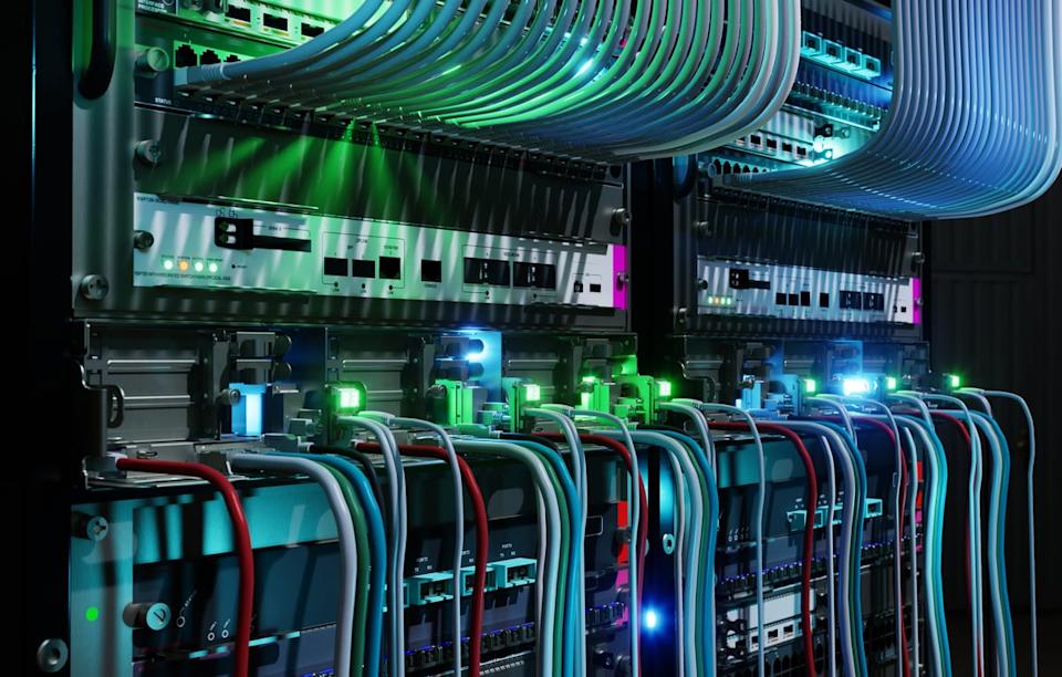 A server rack in a data center with networking cables going in and out of it.