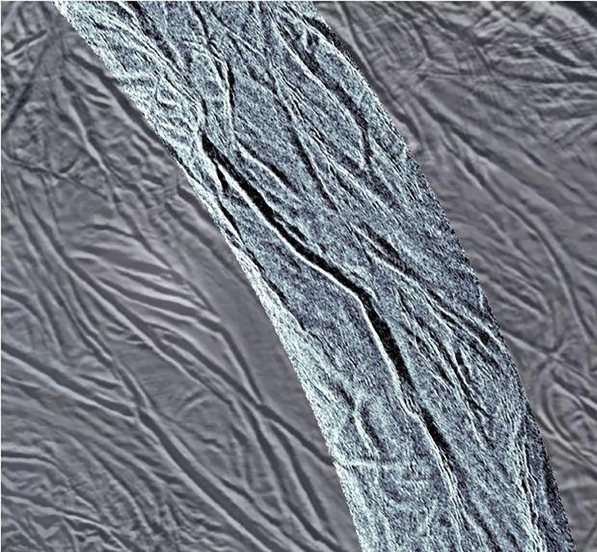 A view of grooves in the southern region of Saturn's icy moon Enceladus. In the centre is a strip of radar data, which has been laid over an earlier visible-light image of the same region. Both sets of data were captured by the Cassini spacecraft. Credit: NASA