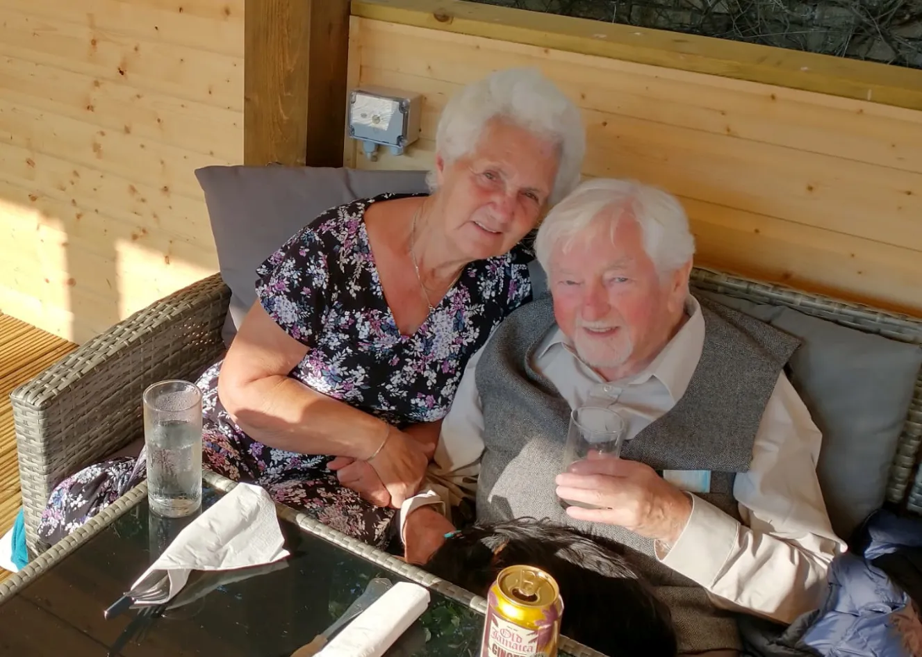 Angus and Agnes McFarlane, parents of Jane McFarlane, sitting together and smiling.