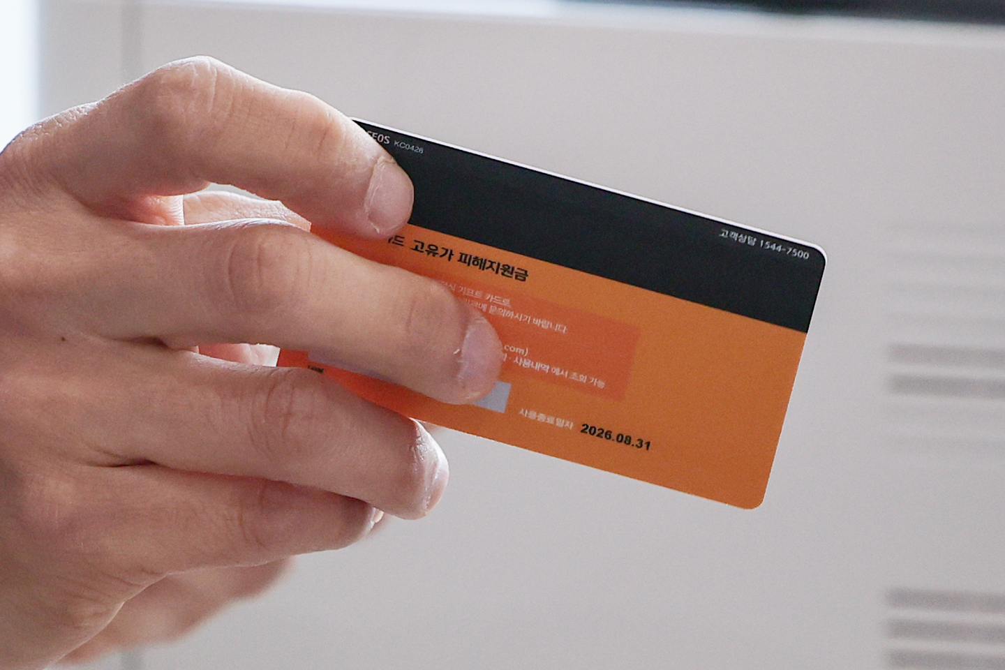 A staff member at a resident center in Gangseo-gu, western Seoul, distributes a relief card on April 27 as part of the first round of payments for high oil price relief funds. [YONHAP]