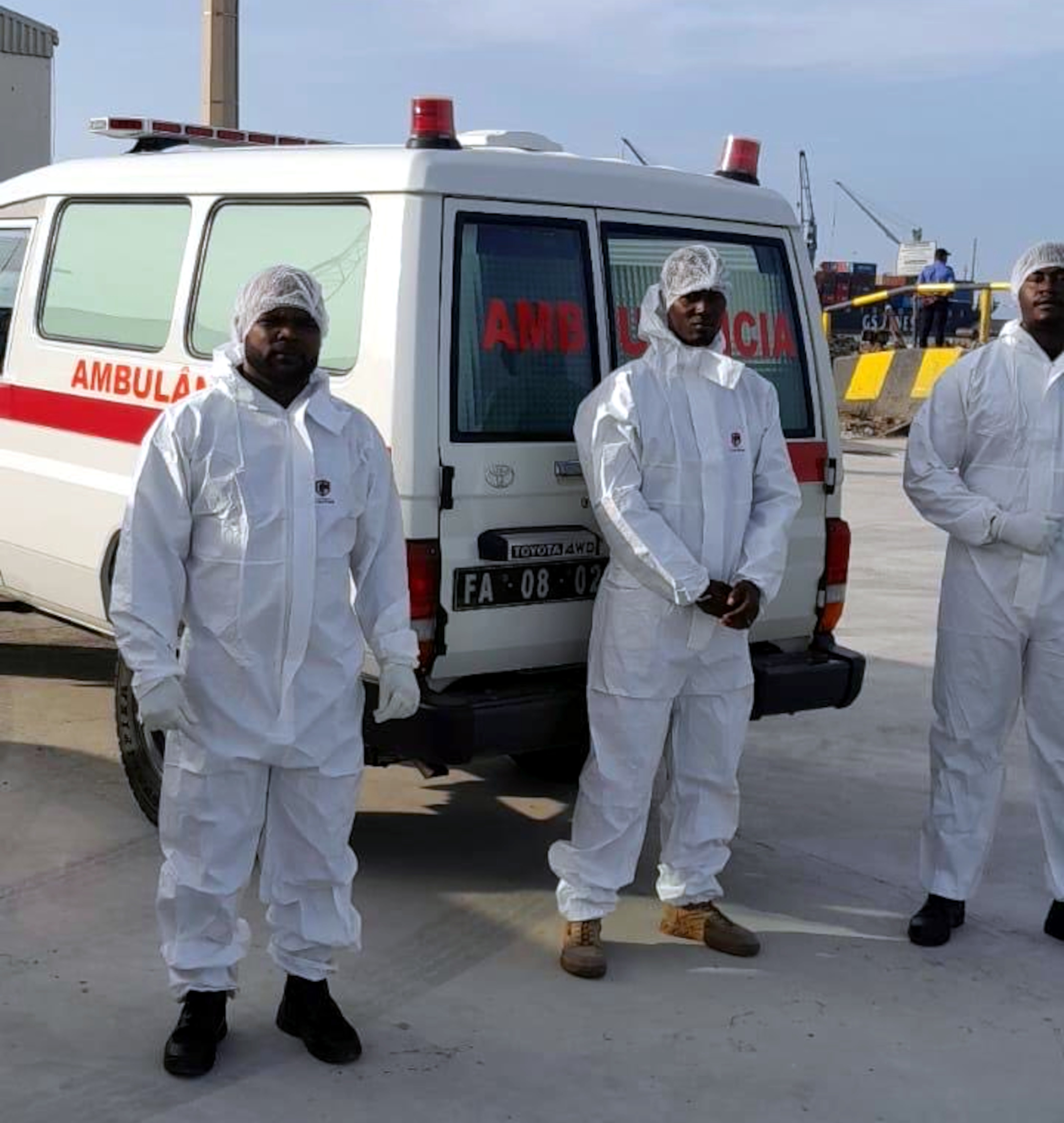 Health workers in front of an ambulance that has transferred hentavirus patients from the cruise ship