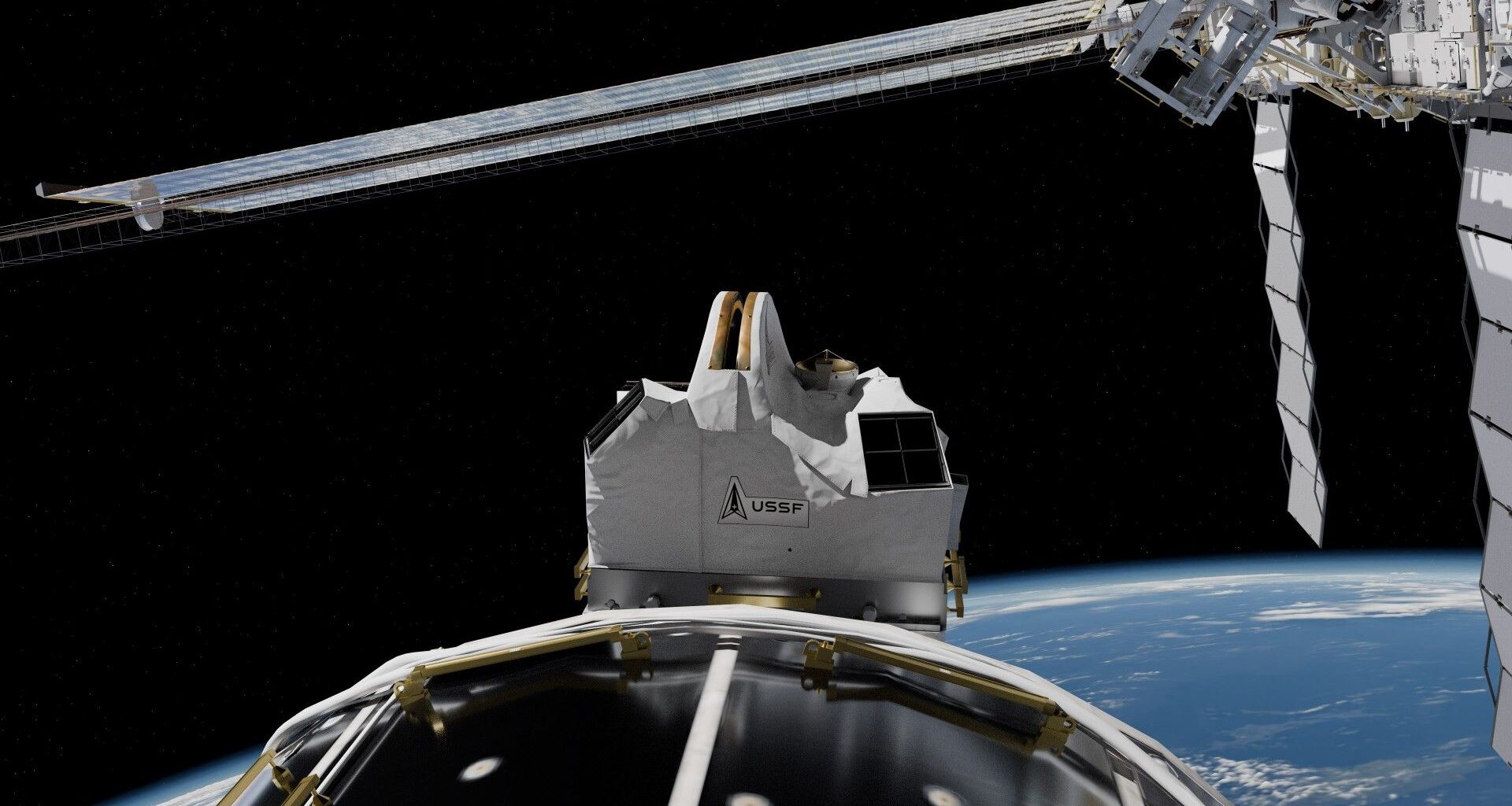 a white rectangular box-like structure on the outside of a large white cylinder above earth