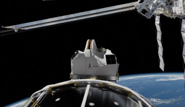 a white rectangular box-like structure on the outside of a large white cylinder above earth