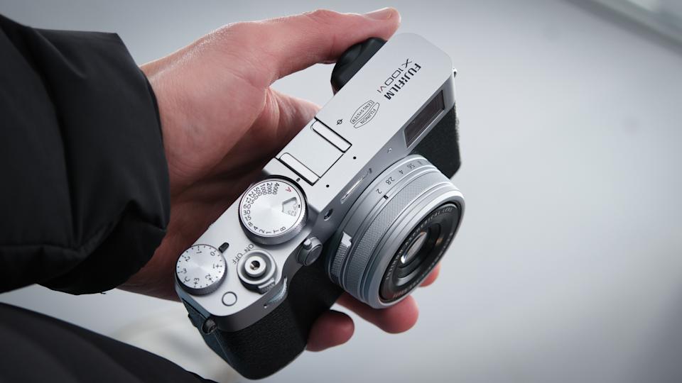 Man holding a Fujifilm X100 VI compact camera in one hand