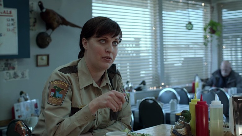 Molly (Allison Tolman) sitting at a diner counter and eating while talking on Fargo S1E2