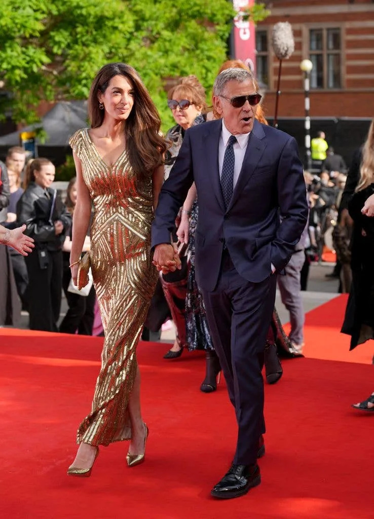 Amal in gold walking red carpet with george clooney