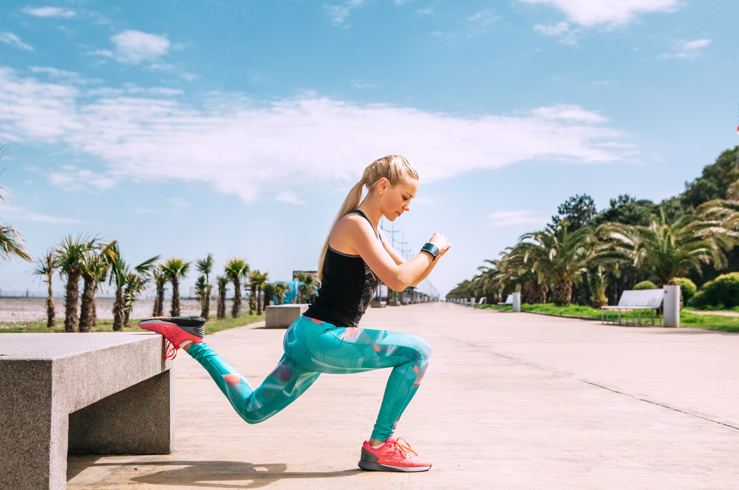 Young woman exercising on a sea embankment.
