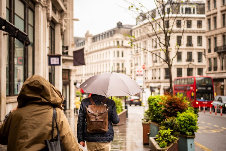 People walking in London with umbrella