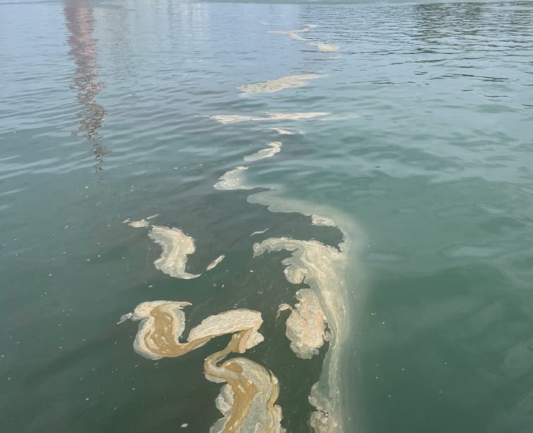 Plume of whiteish material in blue-green sea