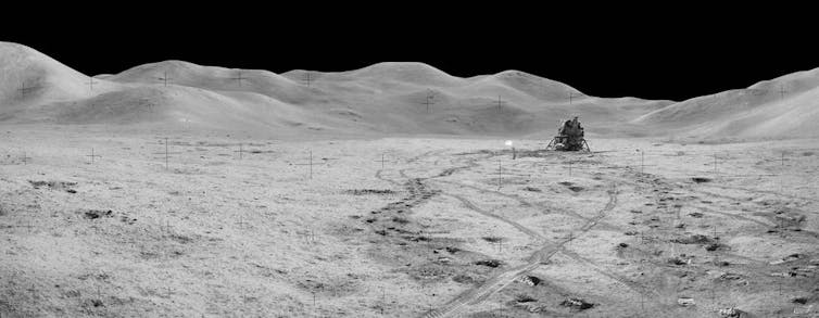The Apollo 15 lander sitting on the surface of the Moon, with a panoramic view of the dusty, rocky lunar landscape.
