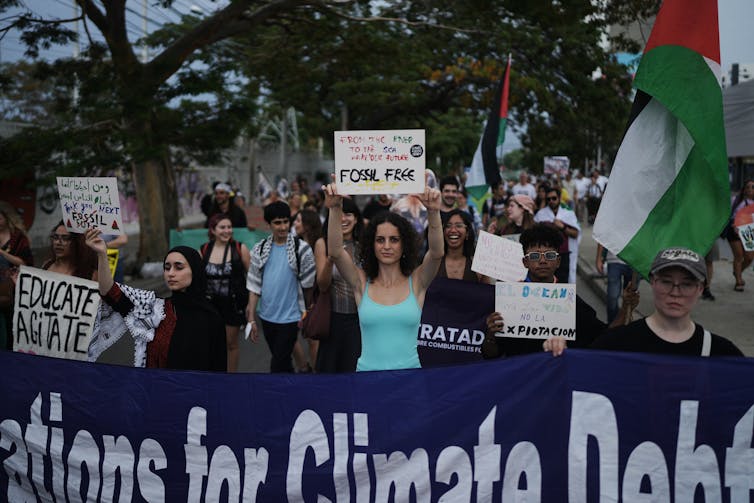 people carry placards and signs at a demonstration
