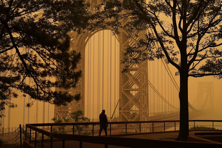 a bridge surrounded by hazy orange sky