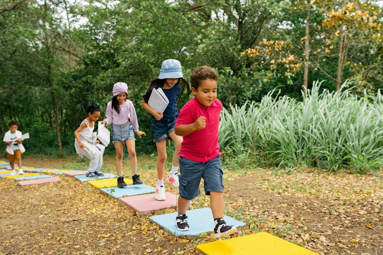 Children walk outdoors.