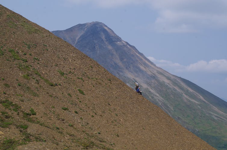 A remote mountain range under grey skies.