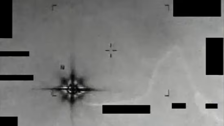 A grainy photo of a dark, blurry object in the sky.