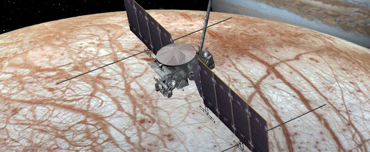 An illustration of a spacecraft flying over an ice-covered moon.