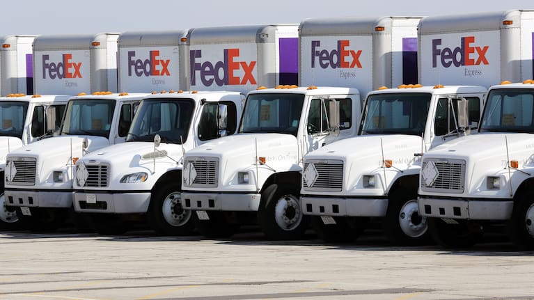 Fleet of FedEx delivery trucks in a parking lot (file image).