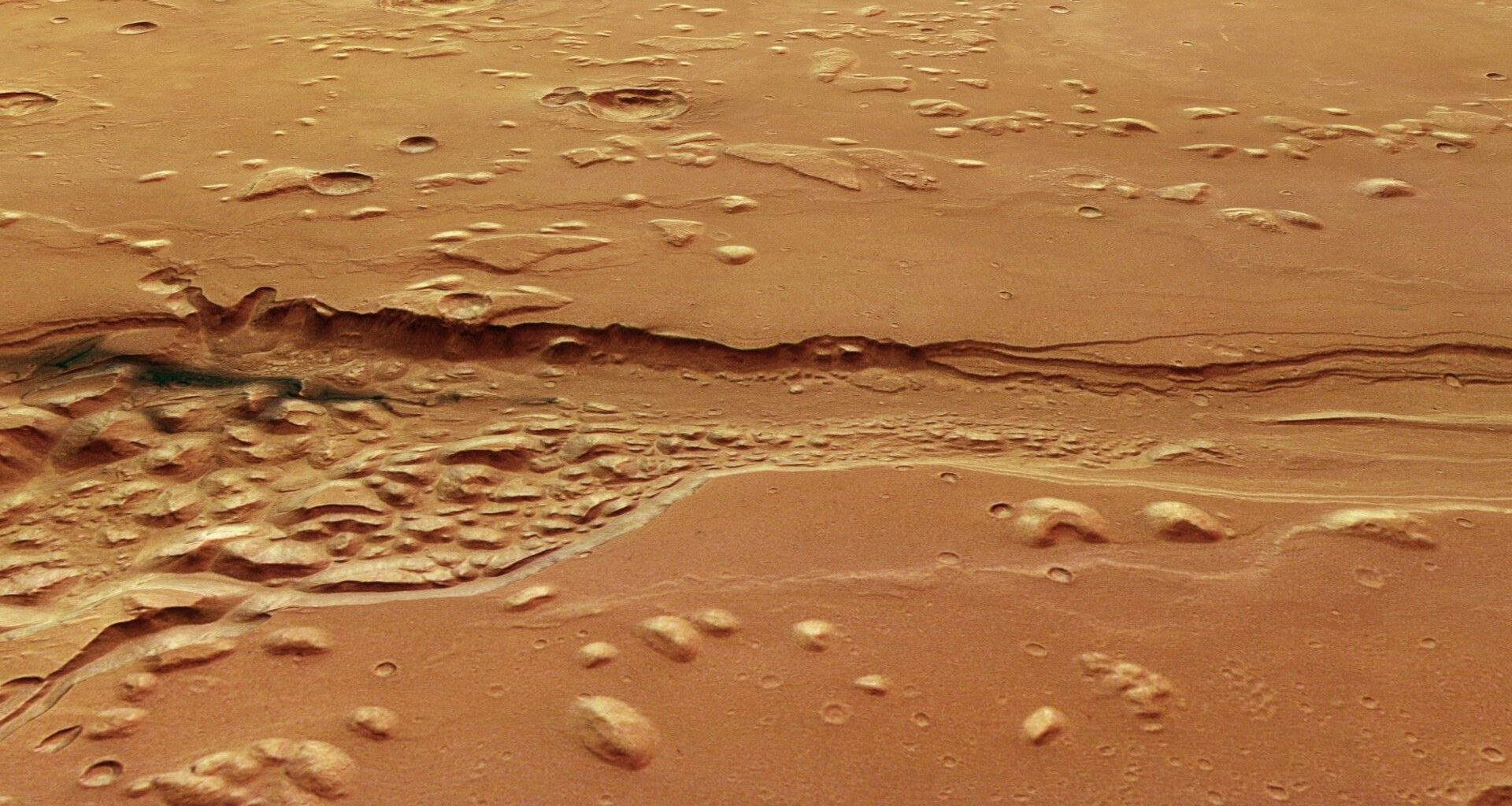 a deep, ragged trench carved into a reddish-orange landscape