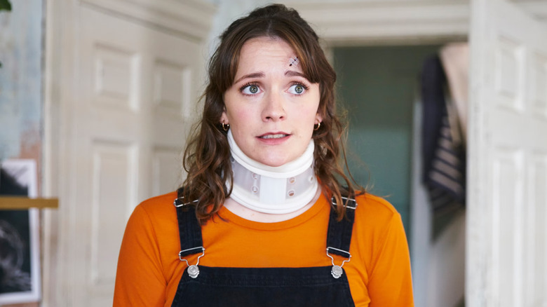 Charlotte Ritchie as Alison wearing a neck brace in Ghosts UK