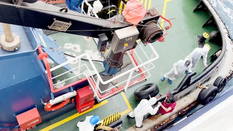 Health workers get off the Dutch-flagged MV Hondius, a cruise ship carrying nearly 150 people as it remains off Cape Verde on Monday, May 4, 2026 after three passengers died and several others fell seriously ill in a suspected hantavirus outbreak.