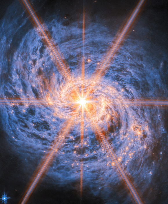 This image of Messier 77 from Webb’s Mid-Infrared Instrument (MIRI) highlights its swirling spiral arms, the dust in its disk and its piercingly bright core like never before. The bright orange lines appearing to radiate out from the galaxy’s center are not actually a feature of the galaxy: they are a type of distortion that arises from the optical design of the telescope. Called diffraction spikes, they are created because the intense light from the unresolved AGN is bent (diffracted) very slightly at the edges of Webb’s hexagonal mirror panels and around one of the struts that hold up its secondary mirror. Image credit: NASA / ESA / CSA / Webb / A. Leroy.