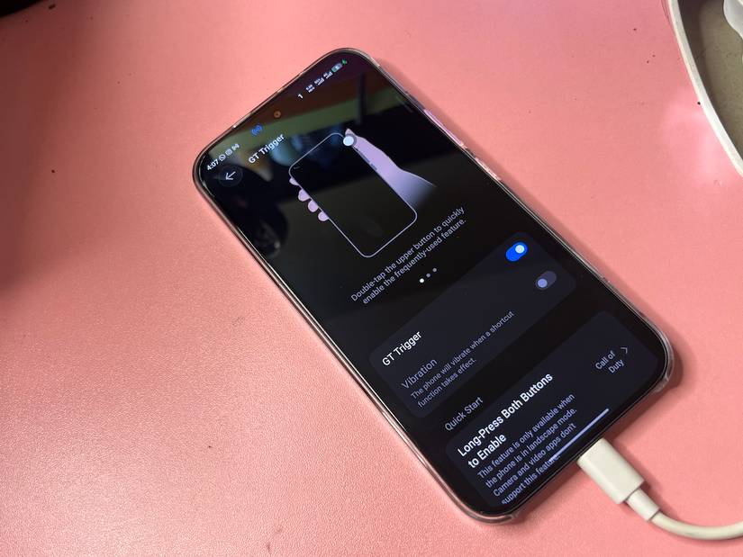 Charging phone showing GT Trigger menu for remapping side buttons