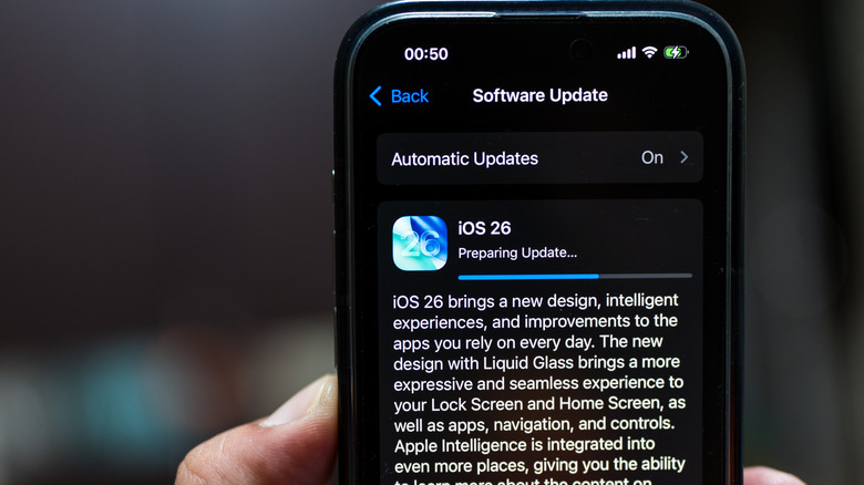 person holding an iphone with the iOS 26 update install underway