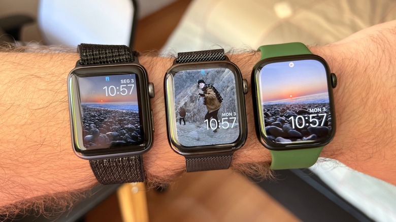 A man's wrist with three different Apple Watch models on