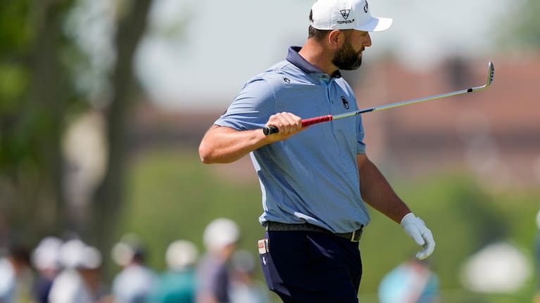 Jon Rahm, of Spain, looks at his club on the third fairway during the final round of the PGA Championship golf tournament at Aronimink Golf Club, Sunday, May 17, 2026, in Newtown Square, PA