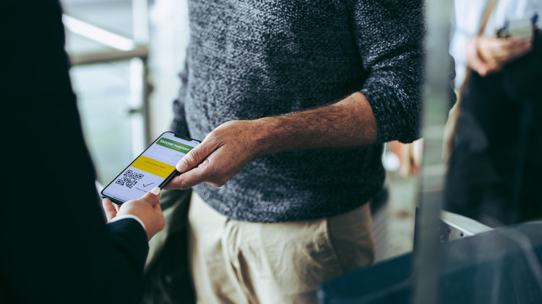 A traveler displaying his covid-19 vaccine passport on a smartphone