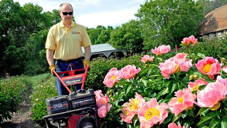Keith Swenson, who runs a family gardening business, tills the ground between rows at a peony acreage near Maple Plain, Minn., on May 20, 2010.