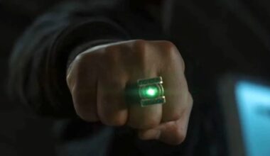 hand clenched in a fist with a glowing green ring on one finger