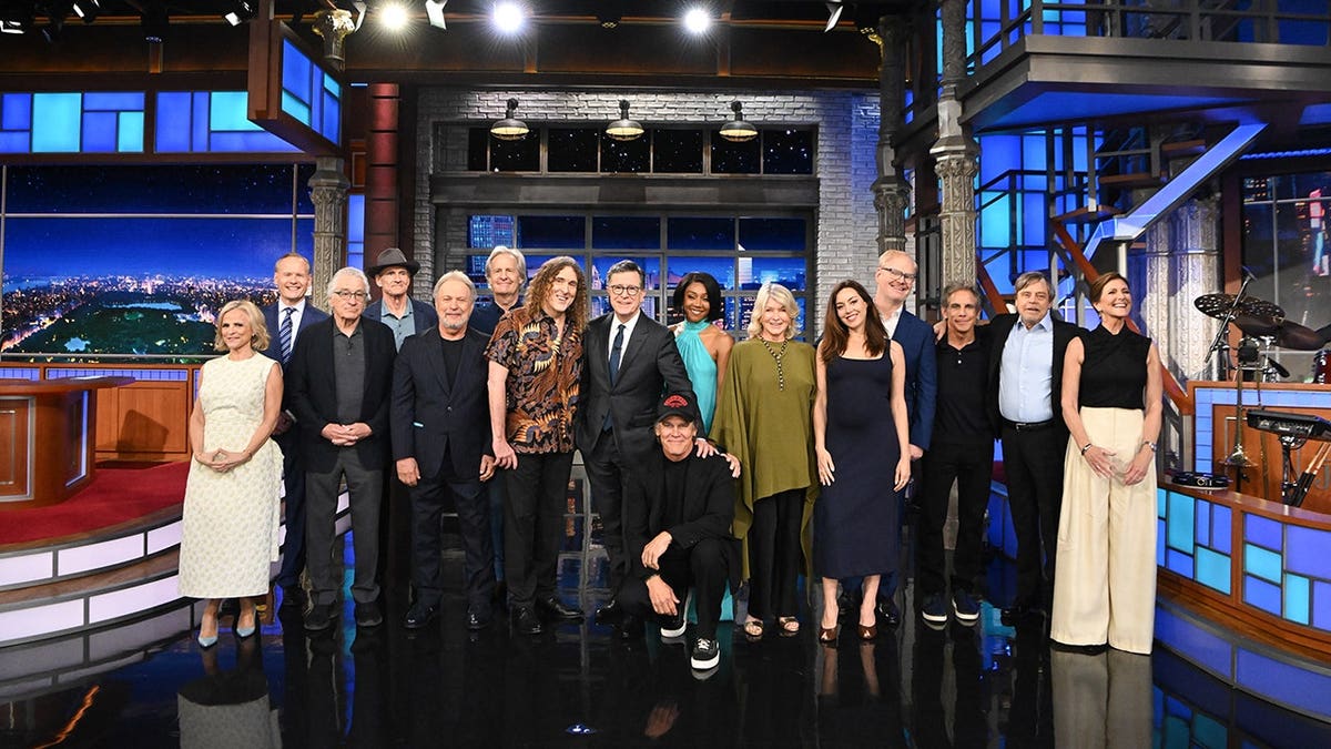 Amy Sedaris, John Dickerson, Robert De Niro, James Taylor, Billy Crystal, Jeff Daniels, Weird Al Yankovic, Stephen Colbert, Josh Brolin, Tiffany Haddish, Martha Stewart, Aubrey Plaza, Jim Gaffigan, Ben Stiller, Mark Hamill and Evie Colbert seated on The Late Show with Stephen Colbert set