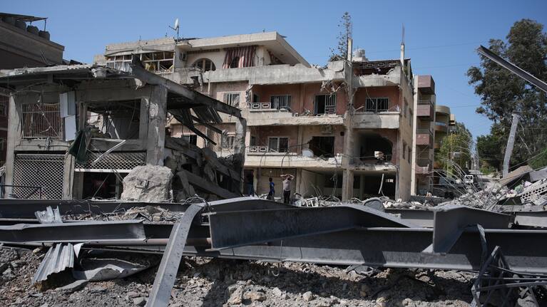 Lebanese residents inspect damage at the site of buildings destroyed in Israeli airstrike.