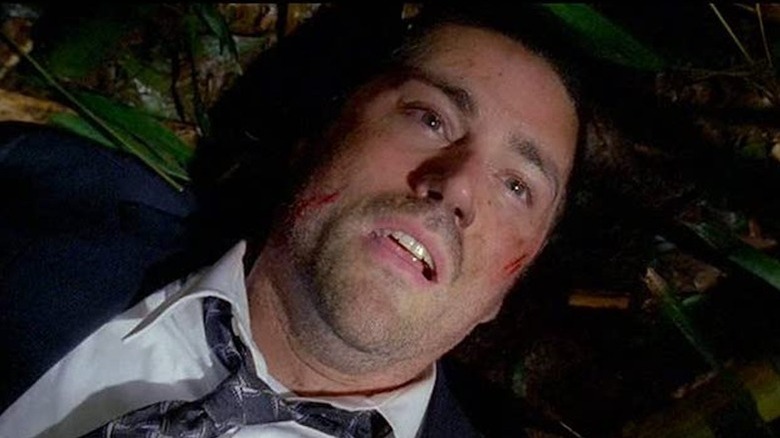 A scratched up Jack Shephard stares up from a jungle ground