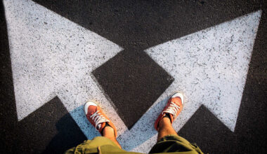 A person standing on a crossroad, with arrows pointing in different directions.