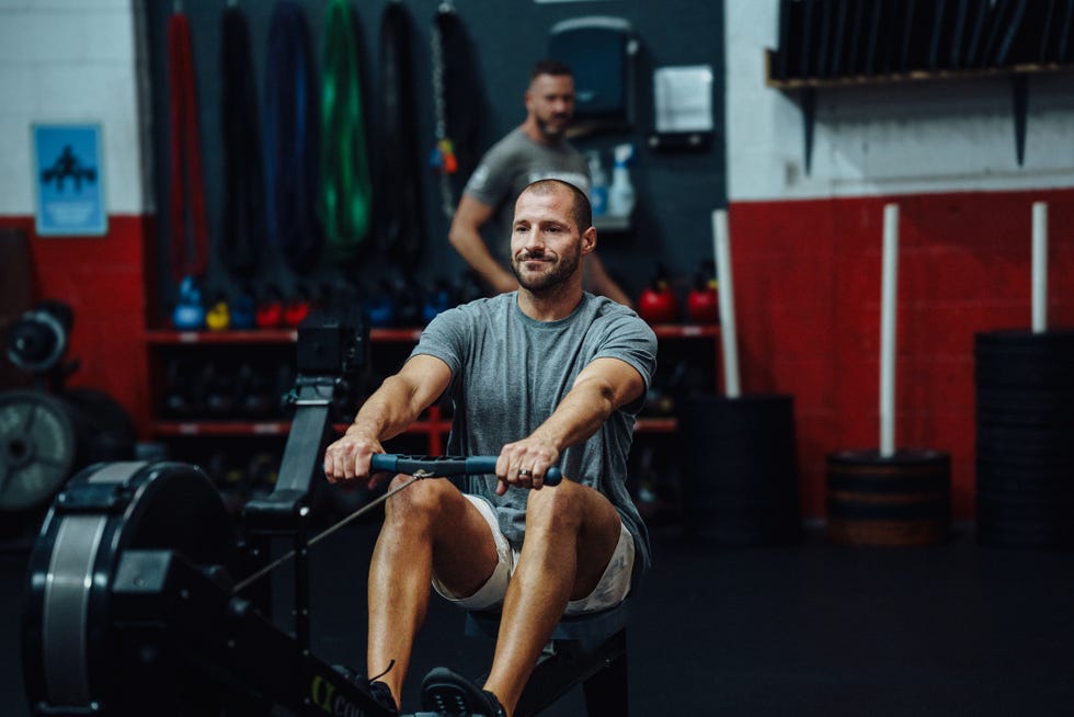 Male athlete uses the rowing machine at the gym male athlete uses the rowing machine at the gym