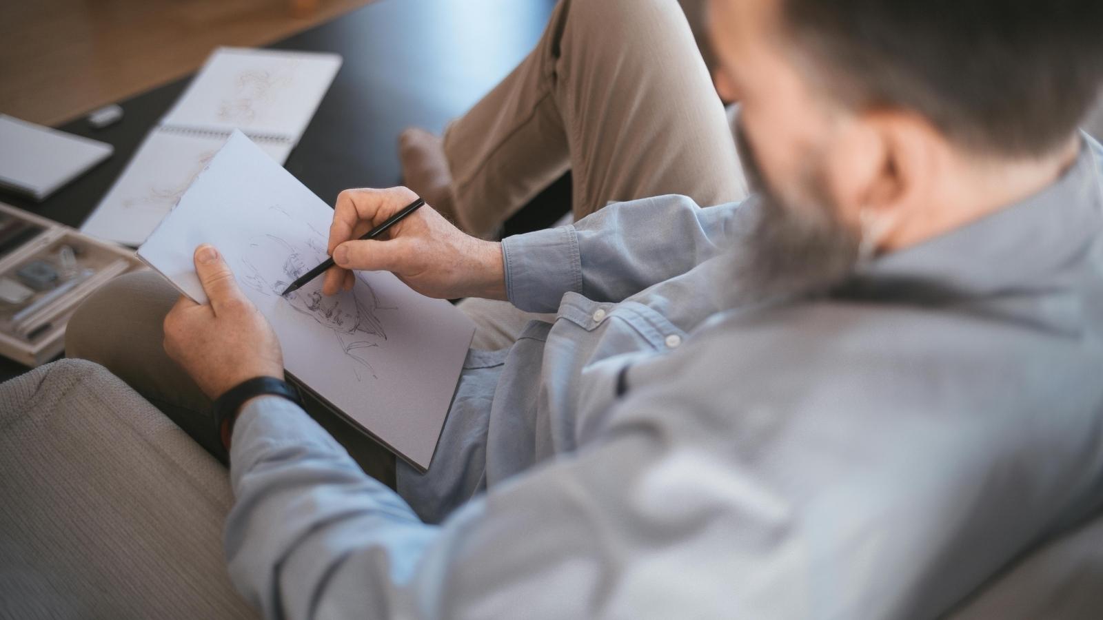 man sketching a drawing