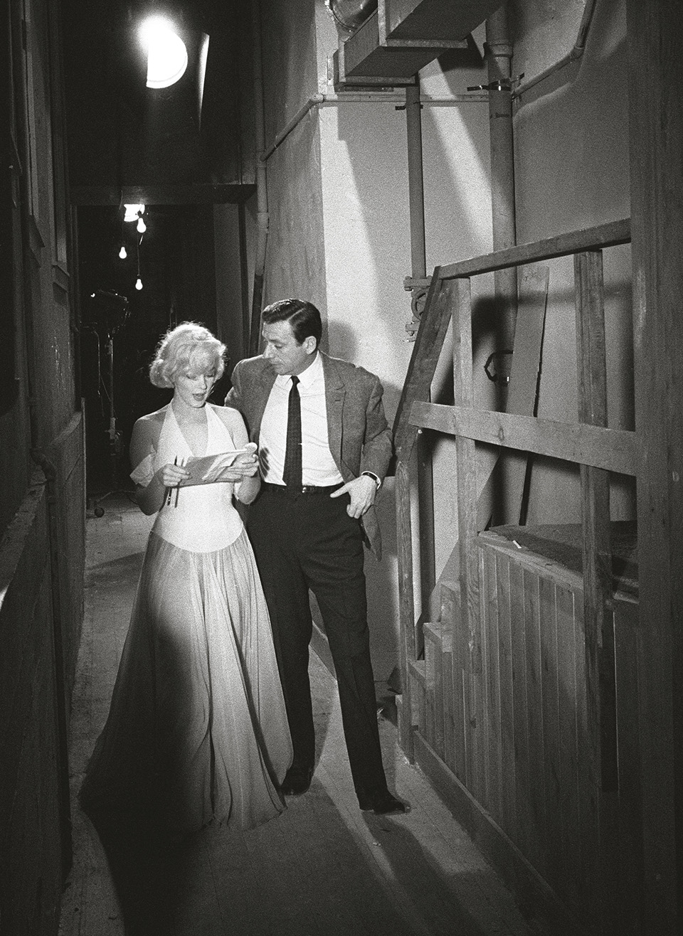 Monroe and co-star Yves Montand discuss the opening scene of “Let’s Make Love” on set, 1960.