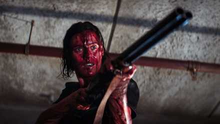 Lily Sullivan holding a gun in Evil Dead Rise.
