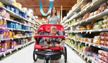 A woman shops in a grocery store while pushing a stroller with a child