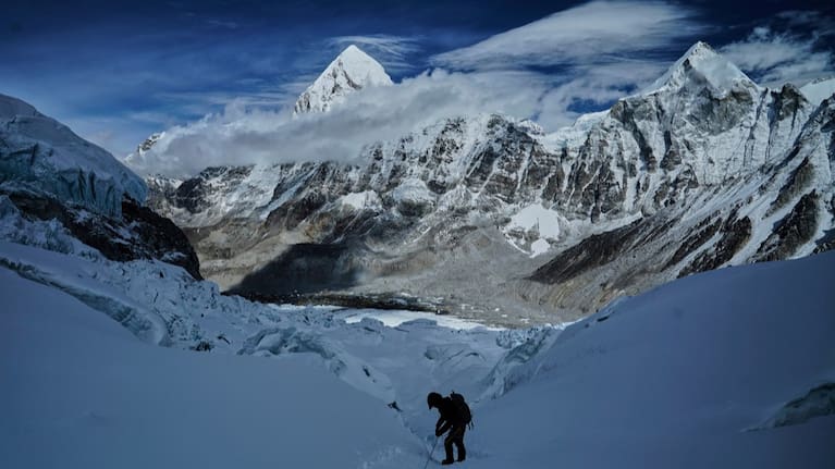 Mount Pumori, centre left, looms in the background as a mountaineer negotiates Khumbu Icefall to descend to Everest Base Camp, in Nepal, May 4, 2025.