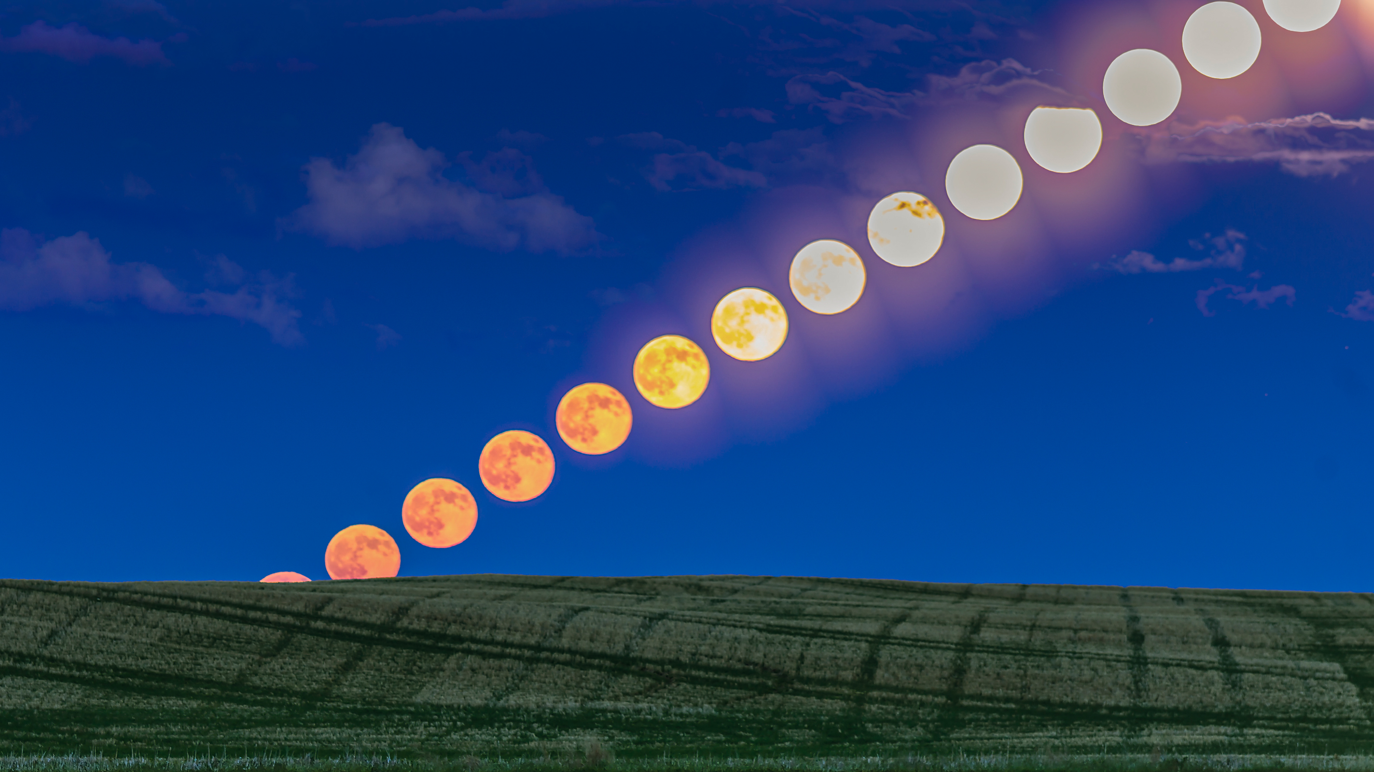 June 9, 2017 - The rising full moon of June, dubbed the Strawberry Moon, as seen rising over a prairie pond in southern Alberta, Canada. At right, the glitter path from the moon also combines on the water. This illustrates the effect of the moon brightening and becoming less red/yellow as it rises into clearer air above the horizon, with less atmospheric absorption of the short wavelengths.