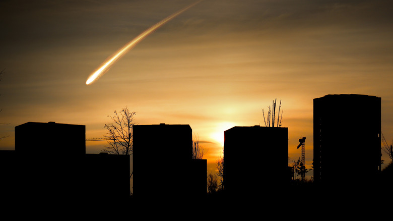 Meteor falling down against city skyline