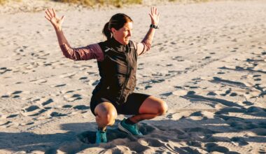 Woman at the bottom of a squat with hands in the air on the beach