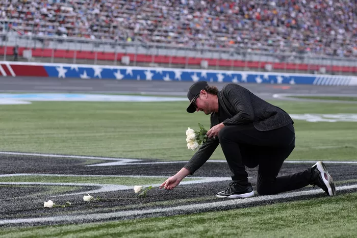 NASCAR Hall of Famer Kurt Busch lays white roses on the