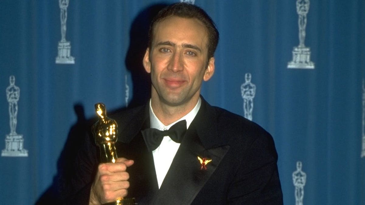Nicolas Cage posing with his Oscar in Los Angeles in March 1996.