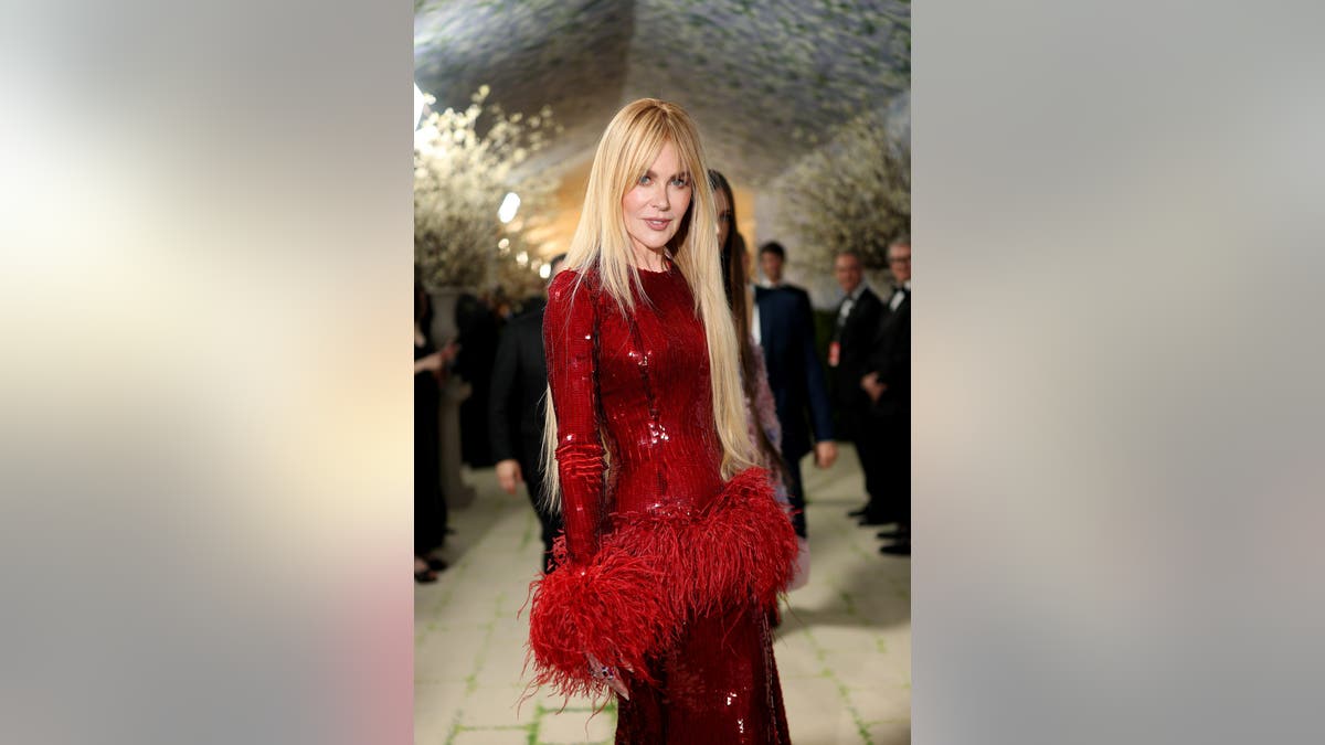 Nicole Kidman standing in a black dress at the Met Gala in New York City