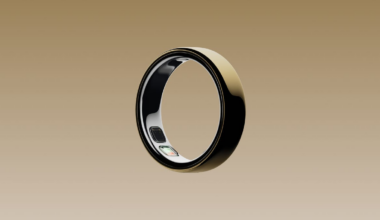 A gold Oura Ring over a gold background.